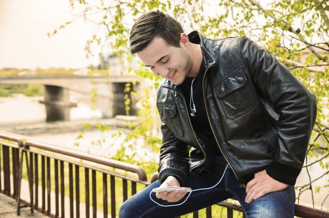 Young man weating a leather jacket, using a smartphone(PhotoAttractive ... Young man weating a leather jacket, using a smartphone(PhotoAttractive ...