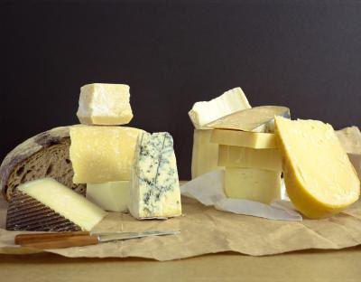 A variety of cheeses on a cutting board.