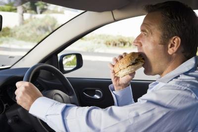 man eating fast food in his car