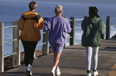 Three women take a morning jog on a pier.