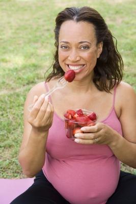 Pregnant woman eating strawberries