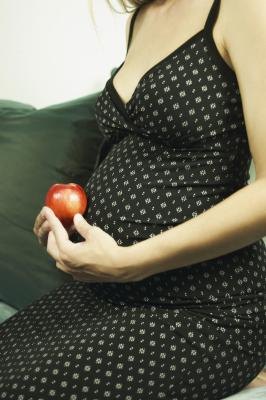 Pregnant woman holding an apple