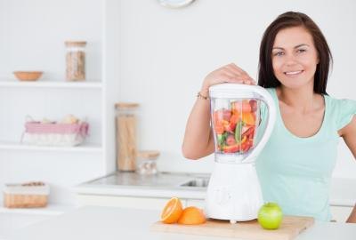 woman with smoothie fruit in blender