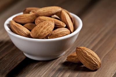 Almonds in a small bowl on a wooden table
