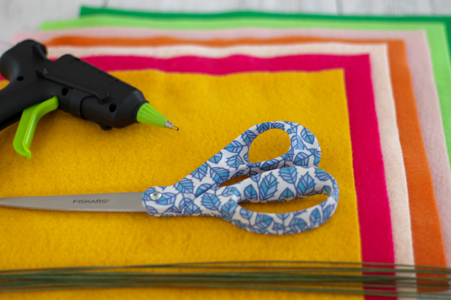 Child holds the scissors and cut out the felt flower. Scissors, hot glue  gun, sheets of felt, decorative pendant with felt butterflies and flowers  Stock Photo by ©OnlyZoia 115559608