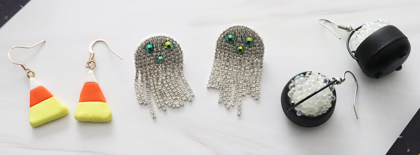 Three pairs of Halloween-themed earrings: candy corn, ghosts and cauldrons