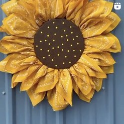 A sunflower wreath hanging on a blue door