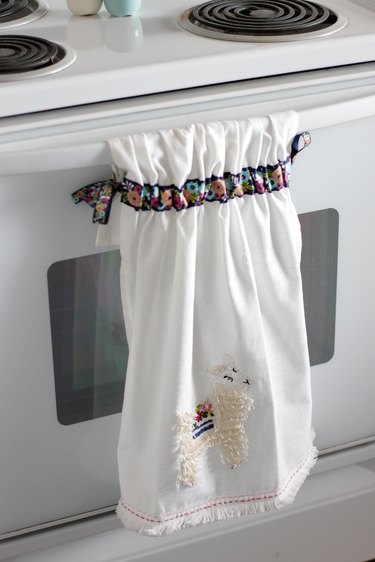 Instead of just hanging your towel over a cupboard door or throwing it on the counter, add a little ribbon to the top so you can give it a place of honor in your kitchen and hang it from your oven door.