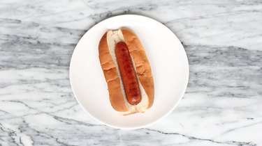 Cooked hot dog inside toasted top slit bun