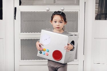 Little girl wearing cardboard robot costume