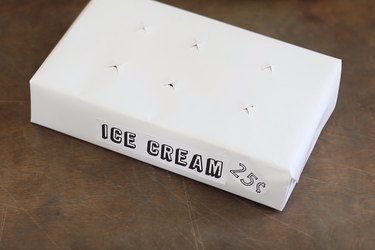 Printed "ICE CREAM" sign taped to front of box