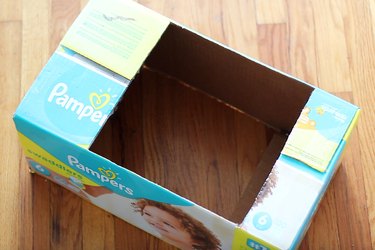 Square holes cut in top and bottom of diaper box