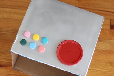 Painted water bottle caps and oatmeal lid glued to box