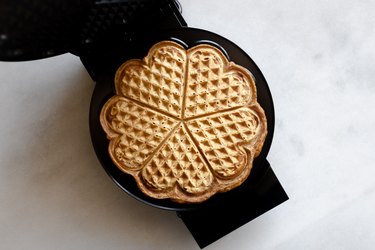 Cook the waffle until it is golden and crisp.