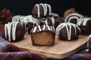 A cut-open gingersnap cookie truffle covered with stripes of drizzled white chocolate.