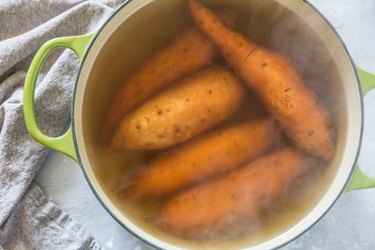 5 sweet potatoes in a pot with water with steam