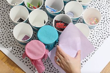 Wrapping tops of cups with tissue paper