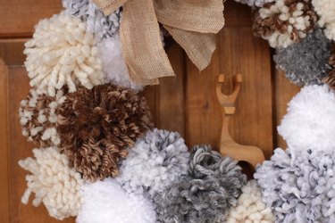'Tis the season to make a cozy yuletide statement with this fuzzy pom pom wreath that you made yourself.