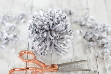 'Tis the season to make a cozy yuletide statement with this fuzzy pom pom wreath that you made yourself.