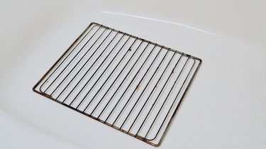 Cleaning oven rack placed in a bathtub