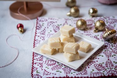 A white plate of eggnog and white chocolate fudge squares.