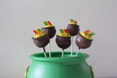 Chocolate pot of gold cake pops displayed in green cauldron