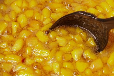 Close up of cooking peaches slowly becoming peach jam