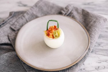Deviled egg with bacon, cheddar and jalapeno toppings
