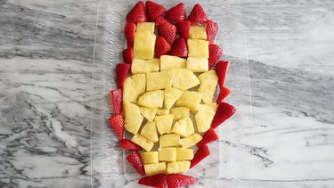 Pineapple and strawberries arranged in Iron Man face shape