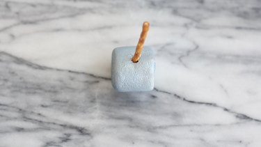 Pretzel stick inserted into silver marshmallow