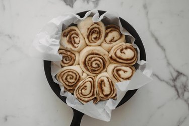 Neatly arrange the cinnamon rolls in the cast iron skillet.