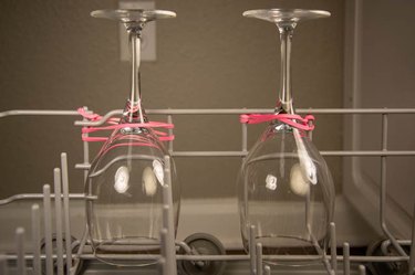 An image of wine glasses in a dishwasher rubber band hack