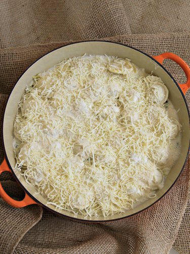 cheese on top of spinach and artichoke ravioli casserole