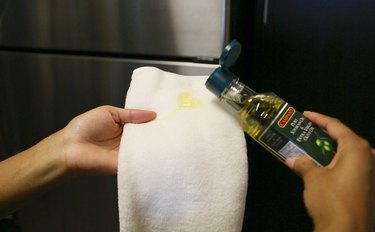 Add olive oil to microfiber cloth