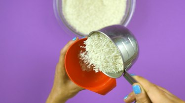 Adding rice to bottle for DIY "I Spy" Bottle Travel Toy