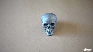 Plastic skull painted with glitter spray paint.