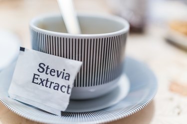 Pequeña taza de café en placa con paquete de extracto de stevia