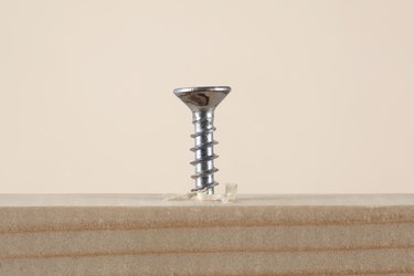 Close-Up Of Nail On Table Against Beige Background