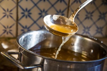 Broth being ladled from saucepan