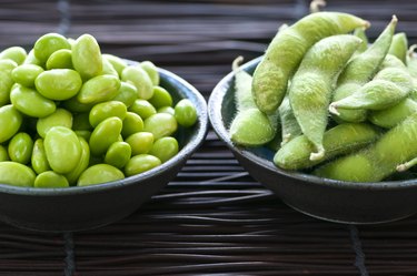 Dos tazones uno lleno de frijoles de soja