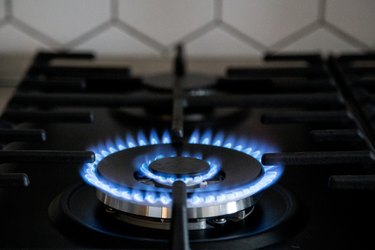 Gas burner on black modern kitchen stove. kitchen gas cooker with burning fire propane gas.