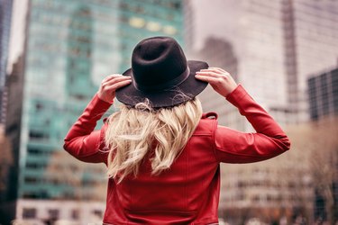 young woman wearing hat walking on streets of New York