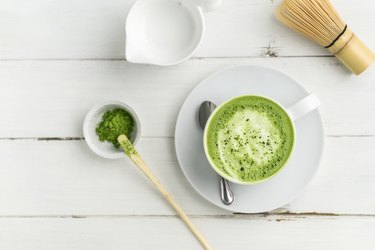 Green tea matcha latte cup on white background from above flat view.