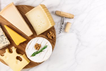 Selection of cheeses with corkscrew, cork, and copyspace