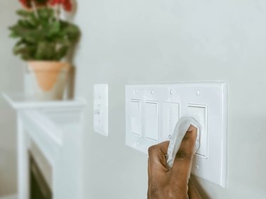 Woman cleans light switches
