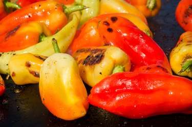 Rojo, verde, amarillo, los pimientos en una parrilla