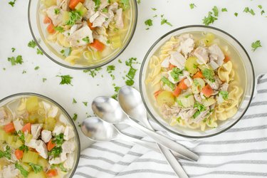 Bowls of chicken noodle soup with vegetables