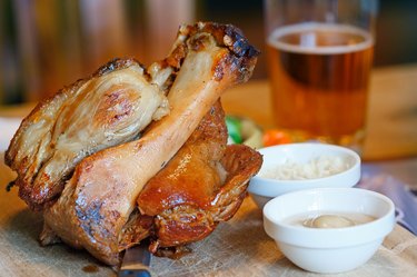 Pork knuckle on a Board with sauces and beer