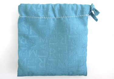 Isolated light blue 100% cotton bag. Canvas fabric with letters. Drawstring bag  White background.