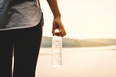 Woman holding water bottle at beach